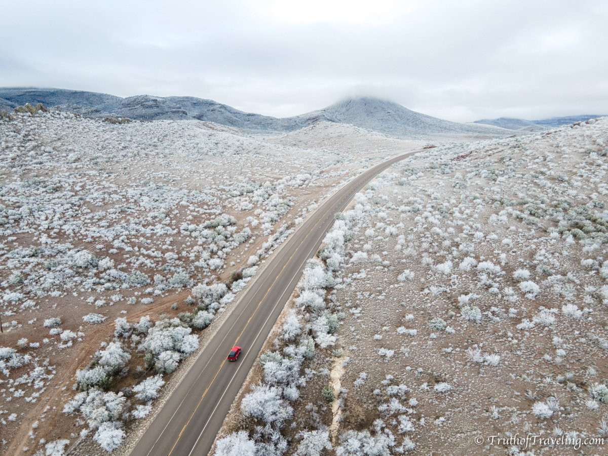Drone shot of driving through snowy road